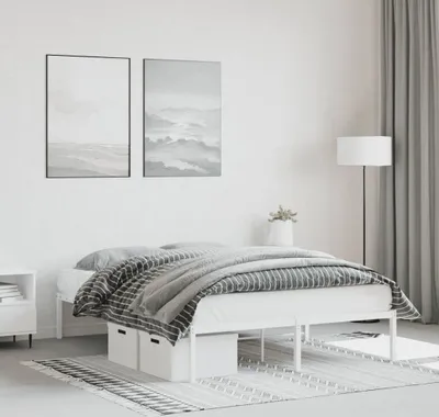 A bedroom scene with a white metal bed frame.
