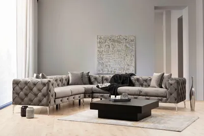 A modern living room with a sectional sofa, coffee table, and artwork.
