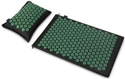 A black acupressure mat and pillow with green spikes on a white background.