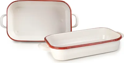 Two white enamel baking dishes with red trim and handles are shown on a white background. One dish is in the foreground, angled slightly, and the other is behind it and to the left, viewed from above.