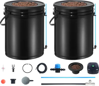 Two black hydroponic buckets with lids filled with brown growing medium, surrounded by various hydroponic system components.