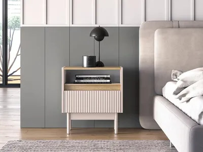 A bedside table next to a bed in a bedroom.