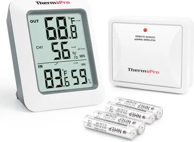 A digital thermometer and its remote sensor are displayed with batteries on a white background.