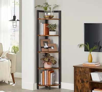 A corner shelf unit filled with books and decorative items, placed in a living room setting next to a sofa and a TV stand.