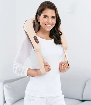 A woman is holding a neck massager around her neck.