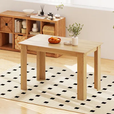 A dining table set up in a room with a shelf unit in the background.
