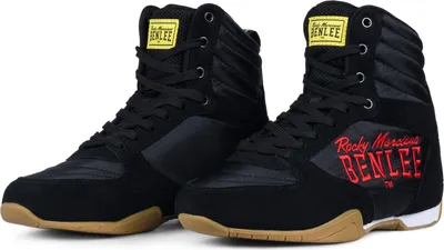 A pair of black boxing shoes with red accents and tan soles.