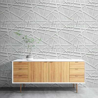 A modern sideboard with wooden drawers and doors is placed in front of a textured, geometric wall paneling.