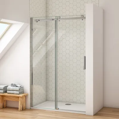 A modern shower enclosure with a sliding door in a bathroom with hexagonal tiles.