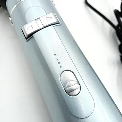 A close-up shot of the controls and body of a hair styling tool.
