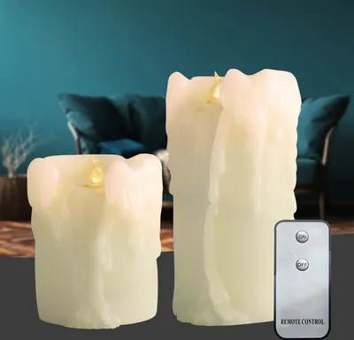 Two LED candles with a remote control in a living room setting.