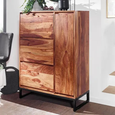 A wooden shoe cabinet with drawers and a door, standing on black metal legs, in a room setting.