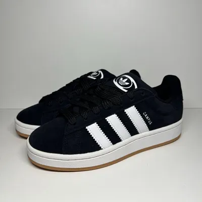 A pair of black Adidas Campus 00S J sneakers with white accents, displayed on a light gray and white background.