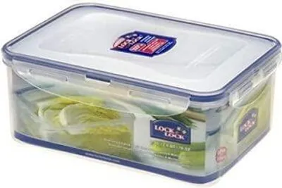A clear plastic food storage container with a blue lid and white seal, filled with lettuce.