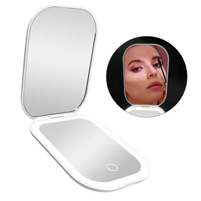 A white, open compact mirror with LED lighting, reflecting a woman applying makeup.