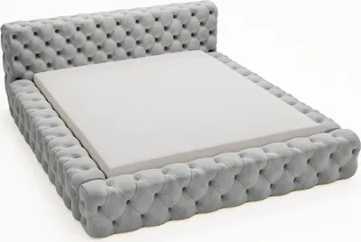 A tufted bed frame with a white mattress base.