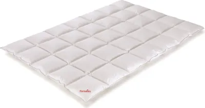 A white quilted comforter laid flat on a white background.