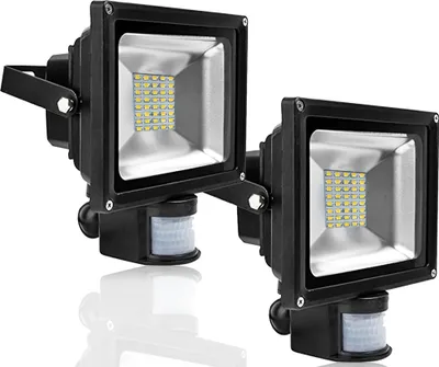 Two black LED floodlights with motion sensors are shown against a white background.