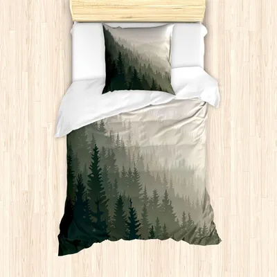 A duvet cover and pillowcase set with a forest landscape print, laid out on a wooden floor.