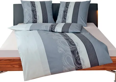 A bed with bedding set, pillows, and a headboard.