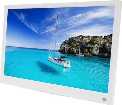 A digital photo frame displaying a scenic image of sailboats on turquoise water near a rocky coastline.