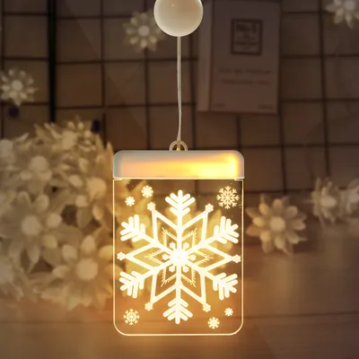 A close-up of a hanging snowflake-shaped Christmas light decoration.