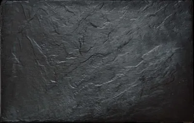 A close-up, top-down view of a dark gray slate-like material.