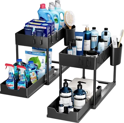 Two black, two-tiered under-sink organizers filled with various cleaning and personal care products.