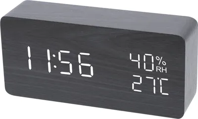 A digital alarm clock with a wood-like finish displaying the time, humidity, and temperature.