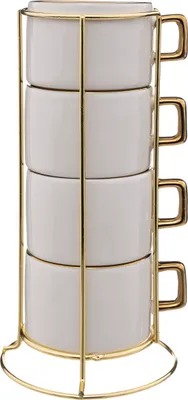 A stack of four white ceramic mugs with gold handles, displayed in a gold wire rack.