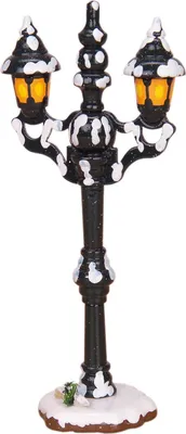 A decorative street lamp with two lights, covered in artificial snow.