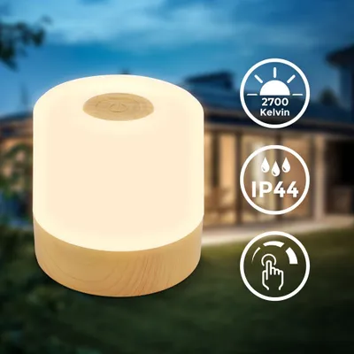 A portable LED lamp with a wooden base is shown outdoors at dusk, with icons indicating its features.