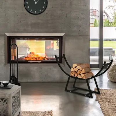A modern living room with a fireplace and a metal firewood rack.