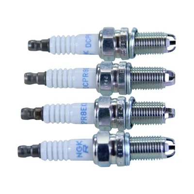 Four spark plugs are laid out horizontally against a white background.