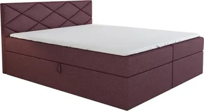 A studio shot of a boxspring bed with a mattress and headboard.
