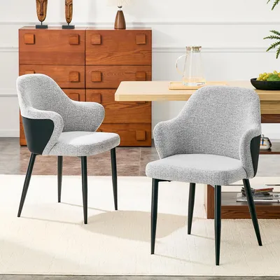Productafbeelding van Set van 2 grijze gestoffeerde stoelen. Hoogte 83 cm. De rugleuning heeft een contrasterende combinatie van grijze stof en zwart Polyurethanaan de achterkant. De stoelen hebben kruisvormige metalen poten voor extra stabiliteit. Kleuren: zwart, grijs