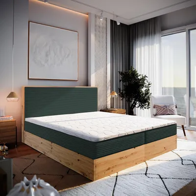 A bedroom scene with a large bed as the focal point, featuring a green headboard and wooden frame, set against a backdrop of a large window with a view of the sea, a chair, and artwork.
