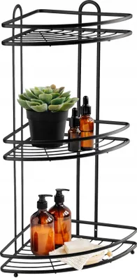A black metal corner shower caddy with three shelves, holding soap dispensers, a potted plant, and a loofah.