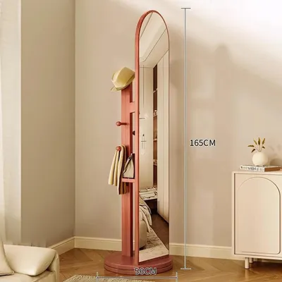 A full-length mirror with a coat rack attachment, displaying a hat and scarves, in a room setting.