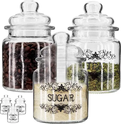 Three glass jars with lids, filled with coffee beans, tea leaves, and sugar, are arranged on a white background. Smaller versions of the jars are visible in the foreground.