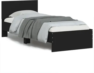 A black wooden bed frame with a white mattress and gray bedding.