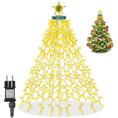 A string of yellow LED lights shaped like a Christmas tree, with a star on top, and a power adapter on the side. A decorated Christmas tree is shown in the background.