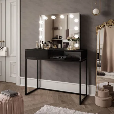 A vanity table with a lighted mirror, makeup, and accessories in a room.