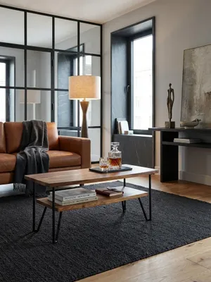 Ein moderner Couchtisch aus Sheesham Massivholz mit schwarzem Metallgestell steht als Mittelpunkt in einem hellen, stilvollen Wohnzimmer auf einem texturierten Teppich._#sku_SAFWL6.720#