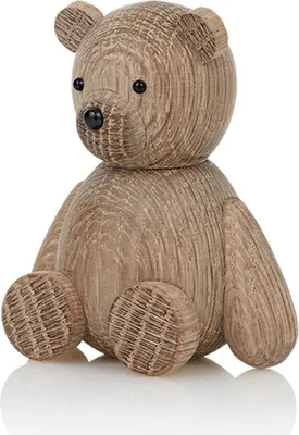 A wooden teddy bear figurine is shown sitting on a white surface.