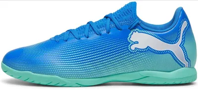 A side view of a blue and green Puma soccer shoe.