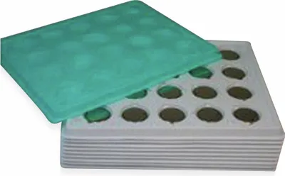 A tray with multiple circular compartments, some containing green and brown items, with a green lid partially covering the tray.