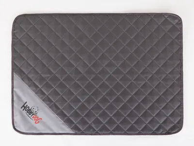 A flat lay image of a quilted dog mat on a white background.
