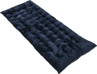 A dark blue tufted mattress or cushion lies diagonally on a white background.