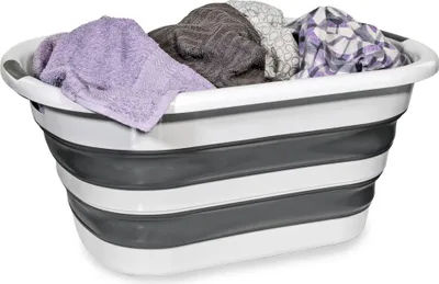 A collapsible laundry basket filled with folded towels and clothes.